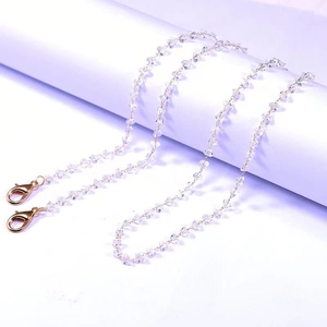 Macro view of clear crystal multi-use chain with golden lobster clasps for eyewear and masks