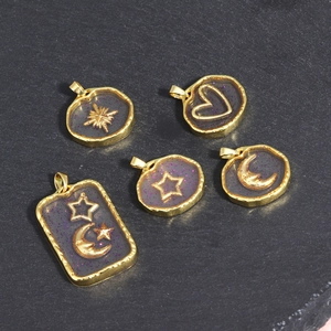 Detail of 5 celestial star and moon charms with gold metal frames and dark resin glitter
