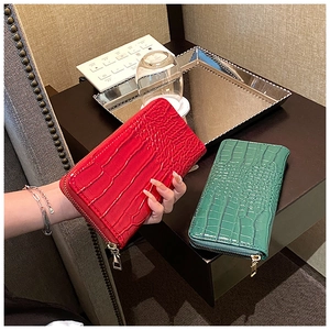 Close-up of crocodile pattern texture on red and green zipper long wallets for women