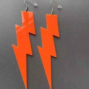 Detailed view of orange acrylic lightning bolt earrings with secure metal hooks and backings