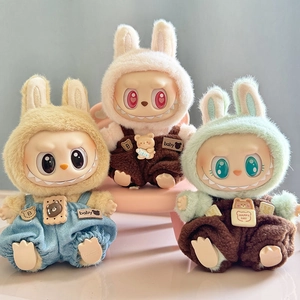 Three Labubu plush toy pendants wearing colorful overalls on a pink and blue background