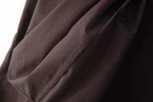 Macro shot of dark coffee poplin fabric showing precise stitching and smooth texture