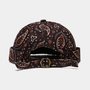 Detail view of the paisley pattern fabric and bronze buckle on the brown miki hat
