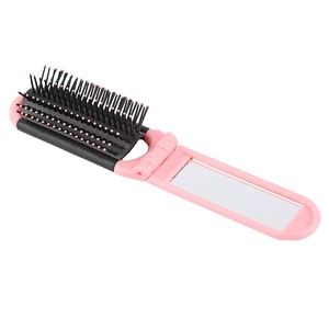 Detail of pink foldable hairbrush with integrated vanity mirror and massage bristles