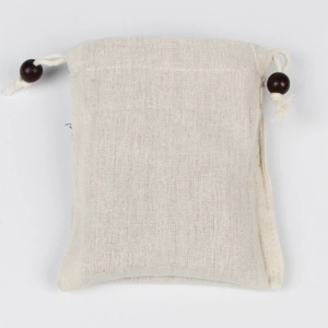 Dettaglio della borsa regalo in lino con trama naturale e perline decorative in legno marrone