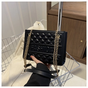 Detail of black embossed tote with golden chain and FASHION lettering texture