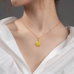 Minimalist titanium steel gold necklace with a round sunburst and snake pendant on model
