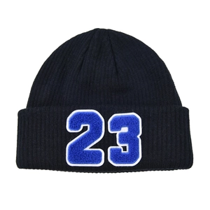 Detalle del parche azul con el número 23 en un gorro de punto acanalado negro de invierno