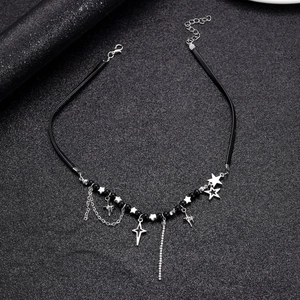 Detail of gothic star pendants and rhinestone tassels on a black punk choker