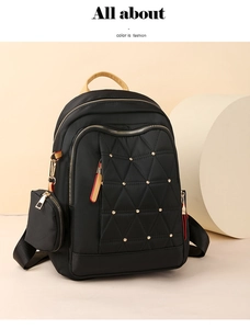 Detalle de mochila oxford negra con cremalleras doradas, remaches y estuche lateral