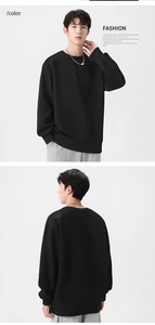 Detail view of black crewneck sweatshirt showing jacquard texture and ribbed cuffs