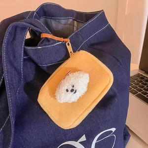 Orange plush coin purse with Bichon Dog design hanging on a blue denim bag