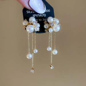 Detail of pearl tassel earrings with gold floral zircon studs and dangling chains