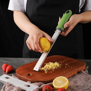 Handheld stainless steel grater for lemon zest and cheese with ergonomic green handle