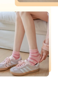 Gros plan de chaussettes en coton à rayures roses avec lettres et baskets assorties
