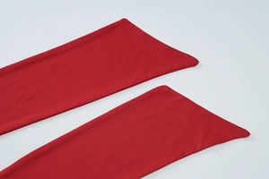 Détail des poignets évasés rouges montrant la couture de qualité et la texture du tissu