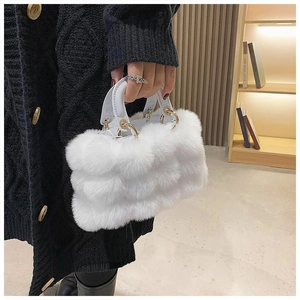 Close-up of white plush handbag with soft faux fur texture for winter fashion