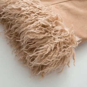 Close-up detail of premium camel suede fabric with soft faux fur trim on the lapel collar