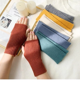 Detail of warm knitted fingerless gloves in various colors showing soft ribbed texture