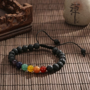 Dettaglio del bracciale chakra in pietra lavica su tappetino in bambù zen