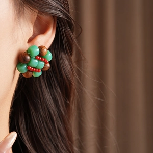 Detailed close-up of ethnic beaded round earrings worn on model with colorful stone beads