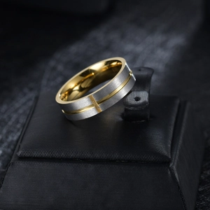 Macro view of brushed silver and gold stainless steel cross section ring on display