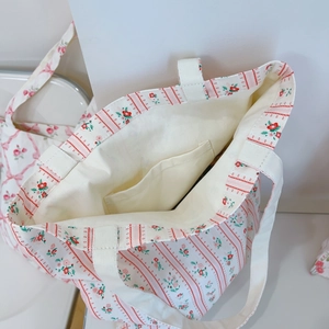 Detail view of the pink flower canvas tote interior showing the inner pocket and lining