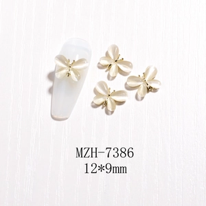 Detailansicht cremefarbener Katzenaugen-Nagelschmuck Schmetterling mit Goldbasis 12x9mm