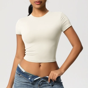 Close-up of a cream slim-fit crop top showing the fine elastic knit fabric texture