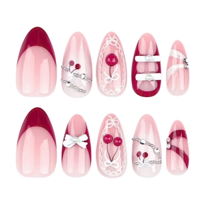 Unghie a mandorla rosa e rosse con design a ciliegia, perle e fiocchi 3D decorativi