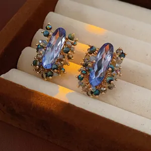 Oval light blue crystal stud earrings with bohemian colorful beaded accents and silver pins