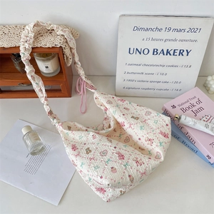 Détail du sac sous les aisselles en tissu crème avec motifs de lapins et ours roses