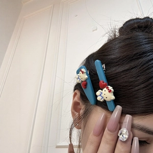 Blaue Acryl-Haarklammern mit Hello Kitty-Figur und Herz auf Model-Haar