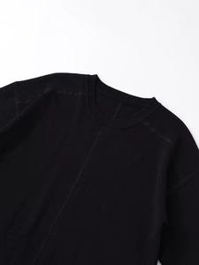 Détail d'un sweat-shirt noir à col rond avec bord-côte et couture centrale décorative