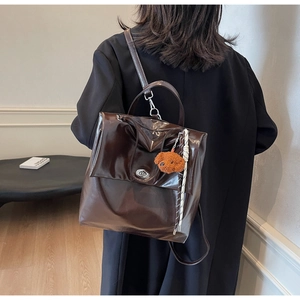 Brown vintage faux leather backpack detail with metal lock and cute dog charm pendant