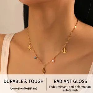 Detail of gold stainless steel necklace with starfish, anchor, and conch charms on a model