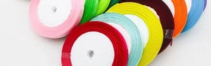 Macro shot of 1cm satin ribbon rolls in various vibrant colors for gift wrapping