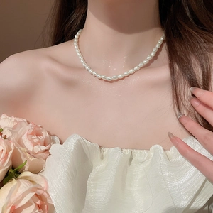 Close-up of elegant pearl beaded necklace on neck with minimalist French style