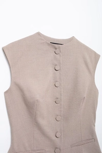 Detail shot of houndstooth plaid vest showing fabric texture and fabric-covered buttons