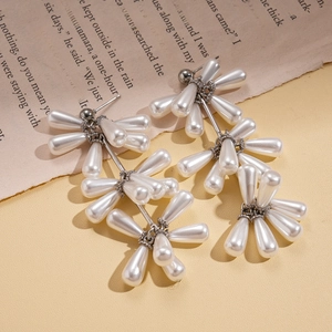 Baroque pearl drop earrings with elegant tassel design on vintage book background