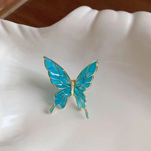 Gros plan de boucles d'oreilles papillon bleu avec bordures dorées sur céramique