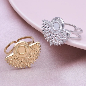Detailed macro view of gold and silver hammered fan-shaped open rings on silk