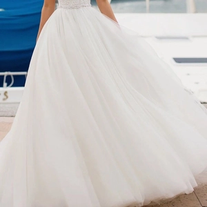 Elegant strapless white wedding dress featuring lace embroidery on yacht background