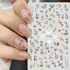 Detail of red bean and butterfly nail art stickers with elegant Chinese calligraphy