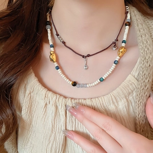 Detail of vintage acrylic coffee bean beads and gold pendant layered necklace set
