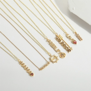 Detailed close-up of various gold MAMA and LOVE pendants with colorful cubic zirconia