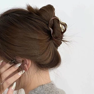 Elegant irregular cloud wave hair claw clip in dark brown and gold on hair bun