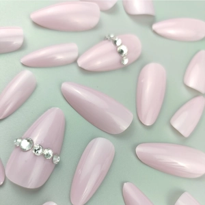 Unghie finte a mandorla lunghe rosa nude con strass argentati scintillanti su base piatta