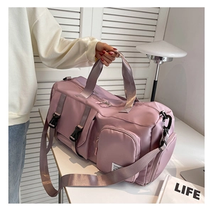 Detail of a pink large capacity travel bag featuring a side shoe compartment and pockets