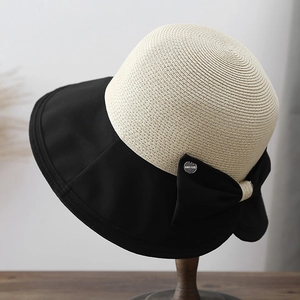 Women's summer straw sun hat with wide black brim and elegant ribbon bow detail